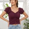 A woman wearing a wine-coloured, ribbed, short-sleeve top with a sweetheart neckline and centre-ruched detail