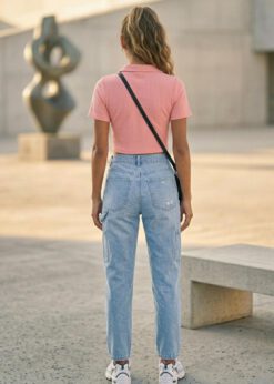 Peach Girl Power Crop Polo shirt worn by a model with high-waisted denim jeans