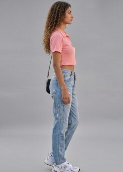 Peach Girl Power Crop Polo shirt worn by a model with high-waisted denim jeans